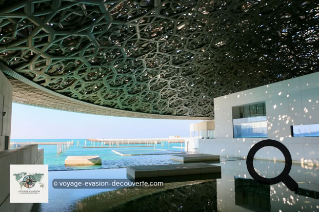 Dès l'arrivée sur l'île de Saadiyat, le bâtiment impressionne par son architecture spectaculaire. Imaginé par l'architecte français Jean Nouvel, le musée ressemble à une cité blanche posée sur l'eau, surmontée d'un immense dôme argenté de 180 mètres de diamètre.