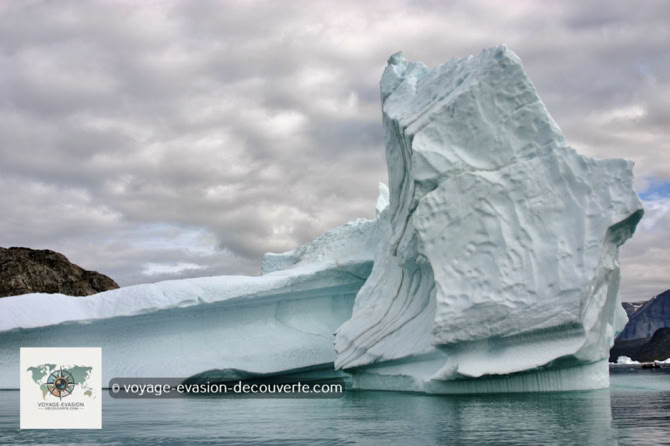 Iceberg au Groenland Les icebergs sont, en très grande partie, de couleur blanche. La glace est remplie de minuscules bulles d'air compressées depuis des centaines d’années. La surface de ces bulles réfléchit la lumière blanche, donnant ainsi aux icebergs cette apparence blanchâtre. Il arrive souvent que les icebergs blancs contiennent des rayures d’un bleu transparent.