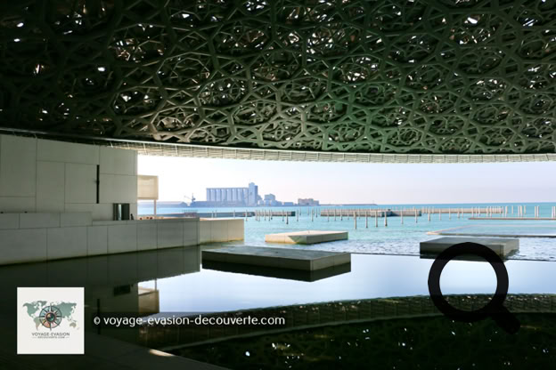 Dès l'arrivée sur l'île de Saadiyat, le bâtiment impressionne par son architecture spectaculaire. Imaginé par l'architecte français Jean Nouvel, le musée ressemble à une cité blanche posée sur l'eau, surmontée d'un immense dôme argenté de 180 mètres de diamètre.
